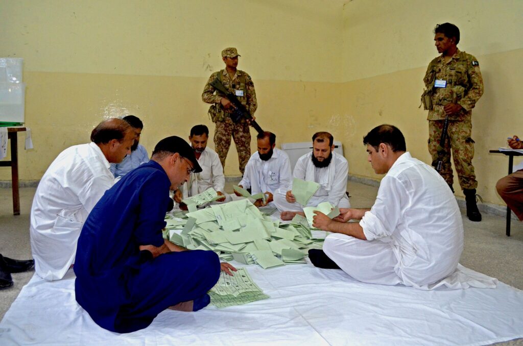 image of election officials hand-counting ballots in Pakistan's 2018 election. Pakistanis are voting on Feb. 8, 2024 in an election filled with drama.